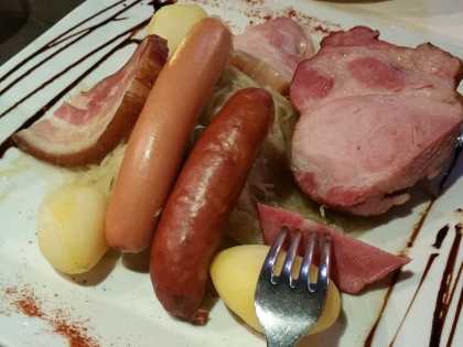 Choucroute mit Wurst, Kassler und Kartoffeln auf einem traditionellen Teller