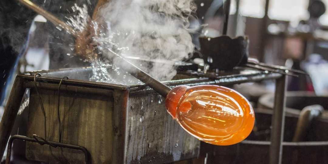 Glasherstellung in einer Manufaktur im Elsass – heißes Glas wird von Hand bearbeitet