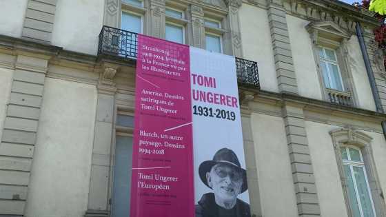 Blick auf die Fassade des Tomi-Ungerer-Museums mit einer Fahne mit dem Bild des Künstlers